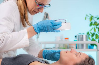 Dermatolojik değişiklikler için hastanın cildini incelemek, koşulları belirlemek ve tedavi seçeneklerini keşfetmek için tasarlanmış teşhis süreci.  