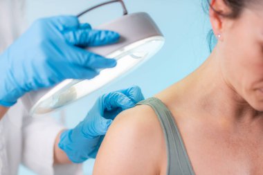 Profesyonel dermatolog dermatoloji kliniğinde çalışıyor. Refahın korunması ve potansiyel endişelerin giderilmesi için düzenli cilt muayeneleri.