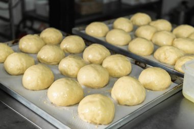 Büyük bir restoranda, hamur topları yemek kağıdına konur.