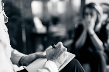 Psikoterapist hasta ile bilişsel davranışsal terapi seansı sırasında not alıyor.