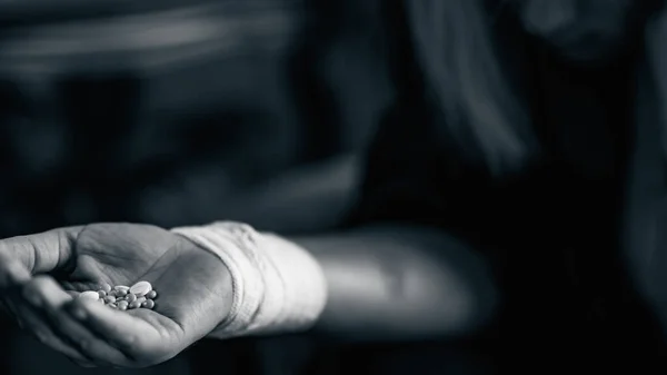 手に錠剤の束を持つ自殺女性 黒と白 — ストック写真