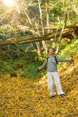 Güzel bir sonbahar gününde orman banyosu. Düşünceli, ruhsal olarak uyanmış bir kadın güzel bir sonbahar gününde orman banyosu tekniği uyguluyor.