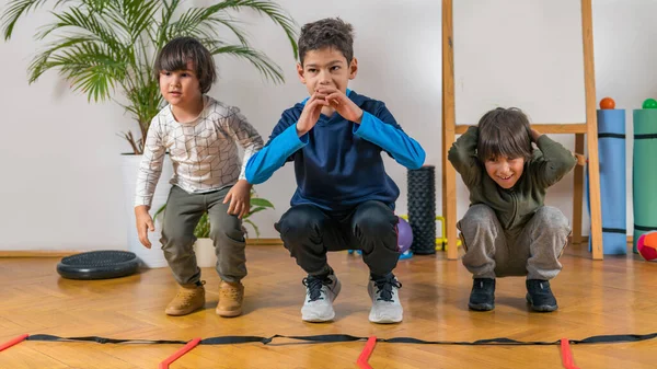 Tres Niños Haciendo Ejercicio Interiores —  Fotos de Stock