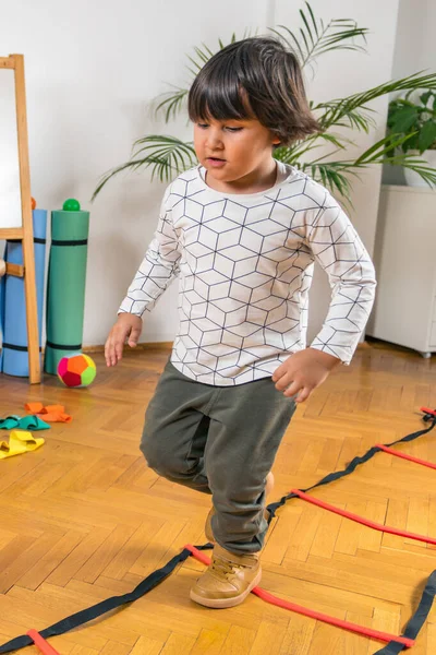 Boy Jumping Ladders Indoors — Stock Photo, Image