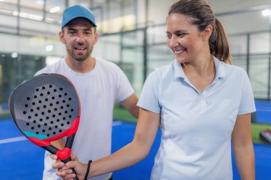 Kapalı alanda Padel eğitimi. Antrenör ve kadın tekniklerini geliştiriyor.