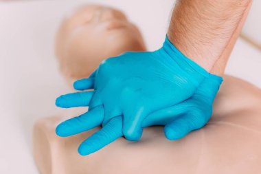 İlk yardım dersinde suni teneffüs öğreniyorum. Antrenman mankeni üzerinde kardiyopulmoner resüsitasyon teknikleri çalışıyorum..