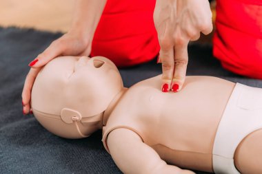 İlk yardım eğitiminde bebek suni teneffüs yapmayı öğrenmek - bebek mankeni kullanarak kardiyopulmoner canlandırma dersi.