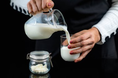 Kadın sürahide ev yapımı kefir dolduruyor..