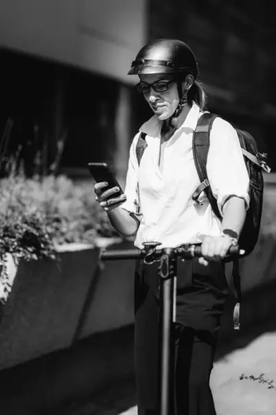 Επιχειρηματίας Στέκεται Και Χρησιμοποιώντας Smartphone Της Ηλεκτρικά Σκούτερ Δίπλα Της — Φωτογραφία Αρχείου