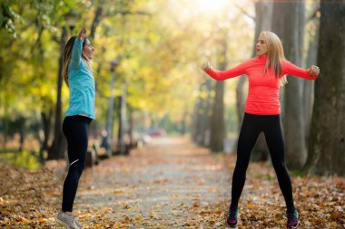 Kamu Parkında Kadın Egzersizi Sonbaharda Kişisel Eğitmenle. Eğitmen Sayma Atlamaları.