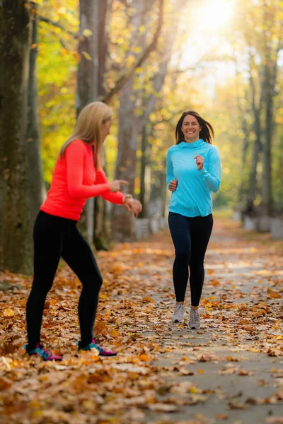 Woman Jogging, Personal Fitness Trainer Looking at a Smart Watch During Training in the Park.