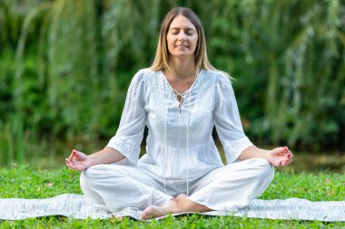 Kadın zarifçe yoga yapıyor, doğası gereği barış ve sükunetle dolu.