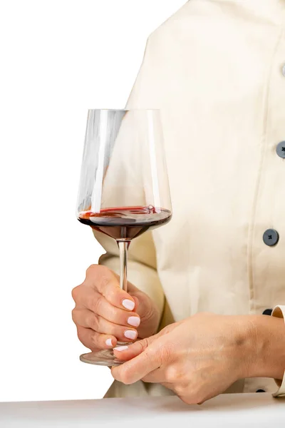 Sommelier swirling red wine in wine glass, close-up, Isolated on a white background