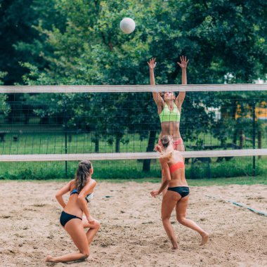 Plaj voleybolu oynayan genç kadınlar