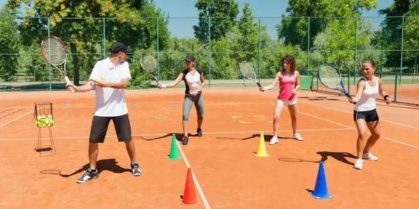 Energetic group participating in a high-energy cardio tennis training session, combining fitness and tennis skills