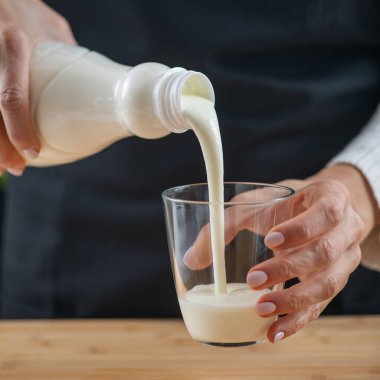 Kefir döken kadın, doğal probiyotikler Lacto ve Bifido Bakterisi ile dolu mayalanmış bir süper yiyecek içeceği..