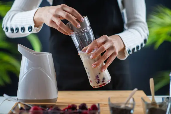 woman Crafting a nutritious shake with the goodness of soy milk and vibrant berries for a delightful wellness treat