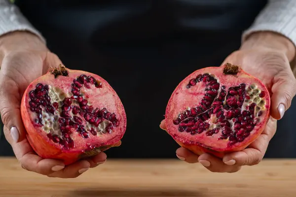 woman holding Vibrant allure of pomegranate, a superfood packed with vitamin C, Vitamin K, potassium, folic acid, dietary fibers, and flavonoids.