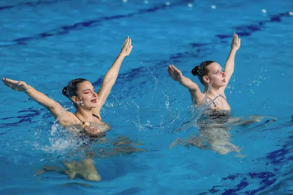 同步的游泳双人优雅地在水中起舞 展示无缝协调 迷人的水上舞蹈编排 — 图库照片