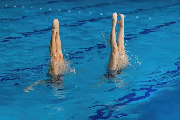 Waterpoëzie Van Een Gesynchroniseerd Zwemduet Dansen Het Glinsterende Zwembadwater Rechtenvrije Stockafbeeldingen