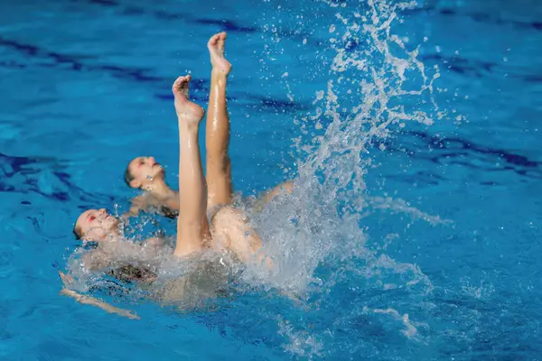 Synchronized Berenang Sebagai Duet Ini Memikat Dengan Gerakan Cairan Dan Stok Foto Bebas Royalti