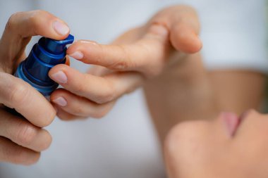 Kozmetikçi kadının yüzüne retinol serumu uyguluyor. Yaşlanma karşıtı faydaları ve cilt tazelemesi ile tanınıyor.