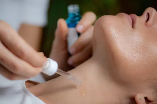 stock image Cosmetician applying hyaluronic acid serum on woman's neck for targeted anti-aging benefits and skin rejuvenation