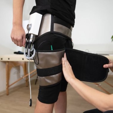 Bacak yontmak için elektro uyarıcı EMS terapisi. Salon terapisti ağırlık yönetimi için bacak hatlarını geliştirmeye odaklanmak için elektrotlar kullanır.