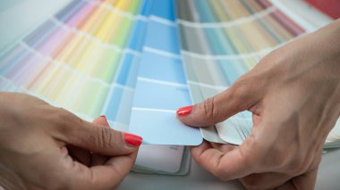 Bir tasarımcı, projeleri için yaratıcı seçenekleri araştırarak bir paletten renkler seçer.