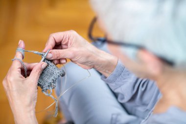 Kıdemli kadın örgü örüyor, örgü örüyor, kıdemli kadınlar bilişsel gelişim yeteneklerini kullanıyor, zihinsel keskinliği ve rahatlamayı teşvik ediyor.