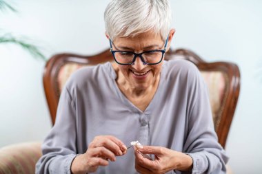 Kıdemli kadın örgü örüyor, örgü örüyor, kıdemli kadınlar bilişsel gelişim yeteneklerini kullanıyor, zihinsel keskinliği ve rahatlamayı teşvik ediyor.