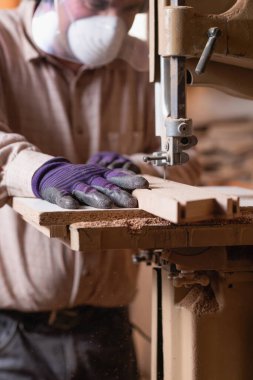 Marangozların elleri bant testeresi, ahşap işçiliğinde odun kesme aleti kullanıyor. 