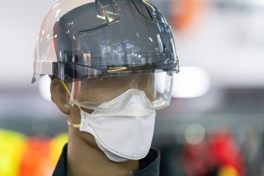 Gerekli güvenlik teçhizatlarıyla donatılmış bir manken. Kasketi ve renkli güvenlik gözlükleri de dahil. İnşaat veya endüstriyel güvenlik ekipmanları için ideal.