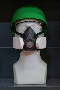 Sıkı bir şapka ve renkli güvenlik gözlüğü de dahil olmak üzere gerekli güvenlik teçhizatlarıyla donatılmış bir manken. İnşaat veya endüstriyel güvenlik ekipmanları için ideal.