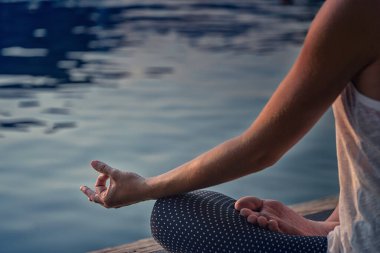 Göl kenarında meditasyon. Kadın eline odaklan.