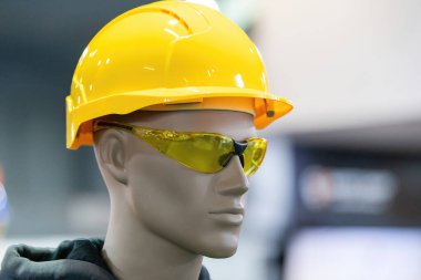 Gerekli güvenlik teçhizatlarıyla donatılmış sarı bir başlık ve renkli güvenlik gözlüğü de dahil. İnşaat veya endüstriyel güvenlik ekipmanları için ideal.