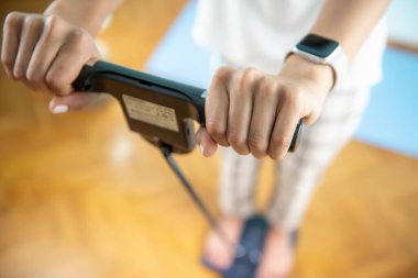 Kadın kendini vücut yağlarıyla tartıyor.