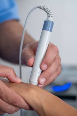 Fizyoterapist hastaların bileklerine lazer terapisi uygular. Ağrı kesiciyi hedef alır ve klinik ortamda iyileşmeyi teşvik eder.