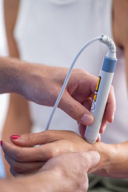 Fizyoterapist hastaların bileklerine lazer terapisi uygular. Ağrı kesiciyi hedef alır ve klinik ortamda iyileşmeyi teşvik eder.