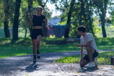 Canlı bir parkta koşuşturan, spor yapmayı kucaklayan ve aktif bir yaşam tarzı olan çift. Bu fotoğraf açık hava egzersizini, sağlığını ve doğada koşmanın keyfini vurgular..