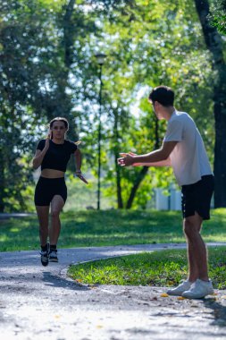 Çift parkta birlikte koşuyor, fitness 'i destekliyor, sağlıklı bir yaşam ve ortak aktif bir yaşam tarzı. Açık hava egzersizini, bağ kurmayı ve manzaralı bir park patikasının enerjisini yakalar.