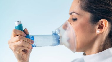 Kadın astımını geliştirilmiş erişim ve rahatlık için ilave tüp içeren bir astım spreyi ile yönetiyor..