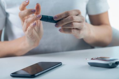 Bir kişi kan şekeri seviyesini ölçer, diyabet ve genel sağlık için temel bir görevdir.