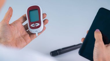 Bir kadın glikoz seviyesini takip eder. Dijital sağlık teknolojisinin kan şekeri seviyelerini kontrol etmek için kullanılması, diyabetin etkili bir şekilde yönetilmesinde önemli bir adım