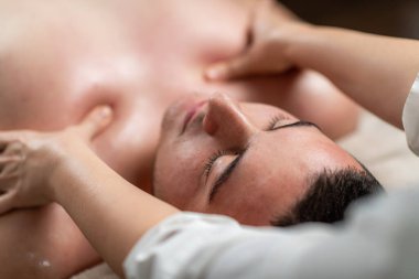 Profesyonel bir salonda rahatlatıcı masajdan zevk alan bir adam. Huzurlu atmosfer, erkeklerin rahatlaması için hazırlanmış sağlık, stres atma ve tedavi tekniklerini vurgular..