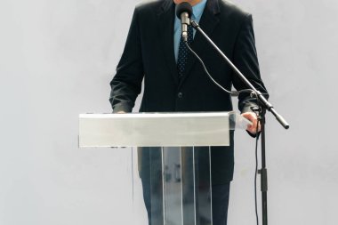 Erkek bir konuşmacı güçlü bir konuşmayla seyirciyi büyüler ve etkili bir an yaratır.