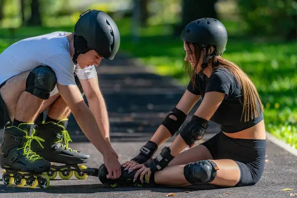 Paten kayan bir çift, bir düşüşten sonra kadına yardım ederken parkta önemli bir anı paylaşır. Sahne takım çalışması, destek ve açık havada aktif bir yaşam tarzını ön plana çıkarıyor.