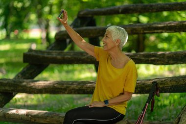 Aktif kıdemli kadın akıllı telefon eğitim sonrası fotoğraf çekimi..