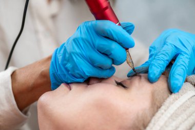 Kalıcı makyaj yapan güzellik uzmanı kaşların görünümünü iyileştiren kozmetik prosedürler yapıyor..