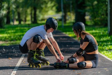 Paten kayan bir çift, bir düşüşten sonra kadına yardım ederken parkta önemli bir anı paylaşır. Sahne takım çalışması, destek ve açık havada aktif bir yaşam tarzını ön plana çıkarıyor.